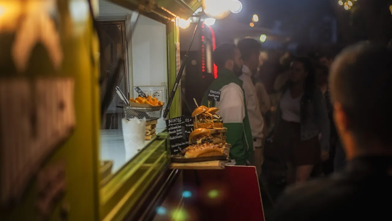 Food truck iluminado à noite com pessoas em uma feira gastronômica