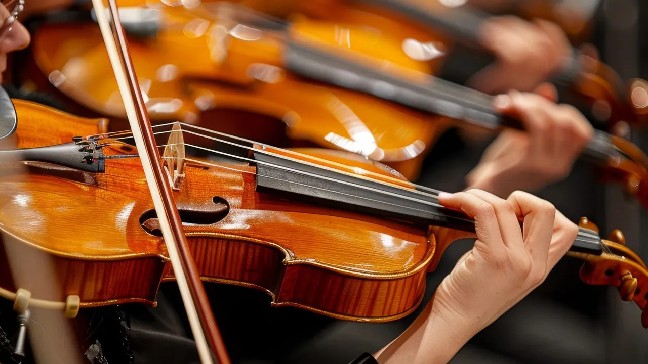 Músicos tocando violinos em uma apresentação de orquestra sinfônica